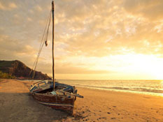 Ein Segelboot am traumhaften Strand bei Sonnenuntergang, der Reisetip vom Reisebüro Ihr Reisezentrum aus Ahrensburg